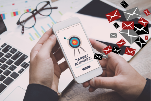 Business professional reviewing target audience strategy on mobile phone with digital marketing and email concept visuals