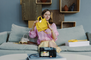 Content creator reviewing a yellow handbag on camera, representing the rise of user-generated content in digital marketing.