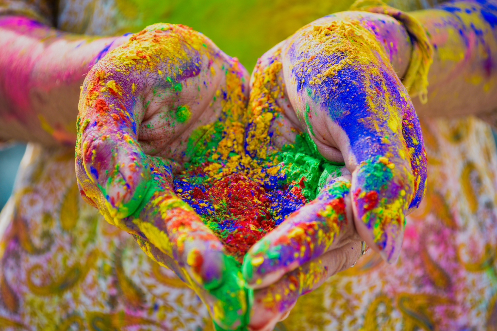 Hands covered in vibrant colored powders, symbolizing the emotional and psychological impact of colors.